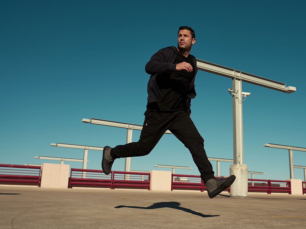 Aubrey Marcus modeling collection pieces in a running pose