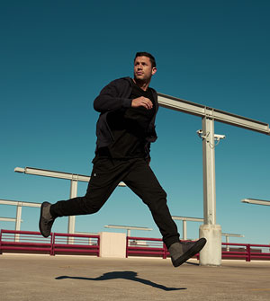 Aubrey Marcus modeling collection pieces in a running pose